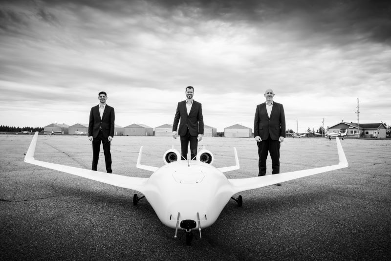 Executives and a prototype aircraft on the runway