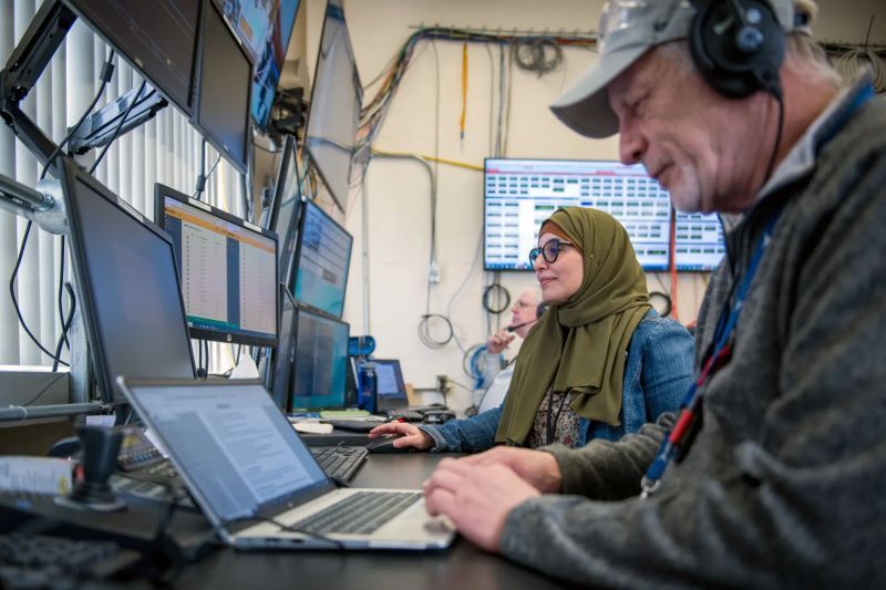 Computers and people monitoring a test