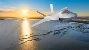White supersonic aircraft demonstrator positioned on sandy beach with water and sunset in background