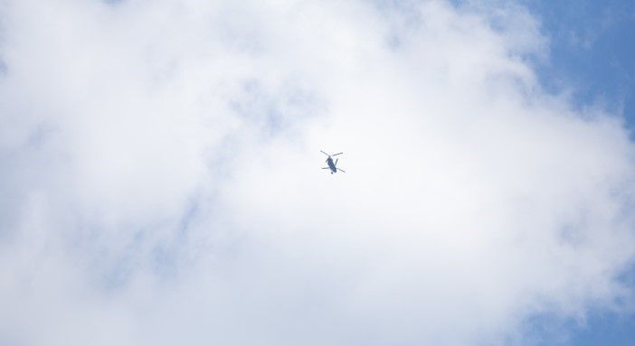Helicopter silhouette against cloudy sky during drop test operations