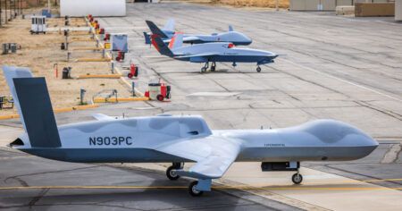 Alt text: MQ-20 Avenger unmanned aircraft flying over desert terrain during autonomous flight demonstration