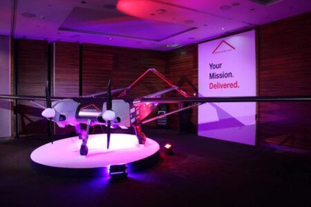 Windracers Ultra twin-engine cargo drone displayed on illuminated platform at London launch event