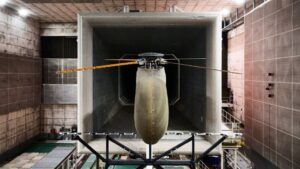 Four-bladed helicopter rotor with model fuselage in large wind tunnel test section with sound-absorbing walls