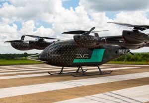 Eve Air Mobility's full-scale eVTOL engineering prototype on the runway at Embraer's Gavião Peixoto test facility, showing the lift-plus-cruise configuration with wing-mounted rotors and rear pusher propeller