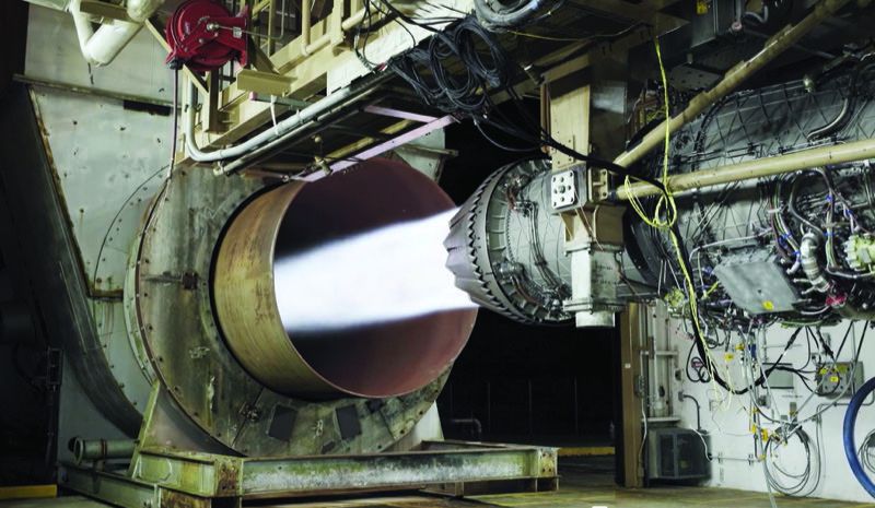 F135 fighter jet engine running on a test stand at Pratt & Whitney's West Palm Beach facility, exhaust plume visible in the test cell