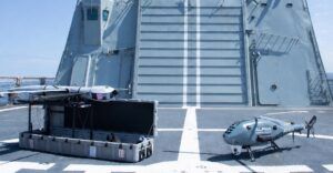 Alt text: Airbus Flexrotor UAS on launcher and Alpha Unmanned Systems A900 rotary-wing drone on the flight deck of Spanish Navy offshore patrol vessel Rayo