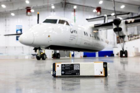 H55 delivers batteries for RTX hybrid-electric demonstrator An H55 Adagio battery module on a hangar floor, with the RTX Hybrid-Electric Flight Demonstrator turboprop aircraft visible in the background