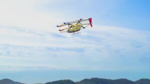 SkyDrive SD-05 multicopter eVTOL aircraft in forward flight against a blue sky above hills