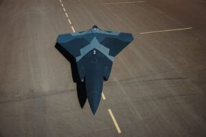 Aerial view of a dark, angular uncrewed aircraft concept parked on a runway