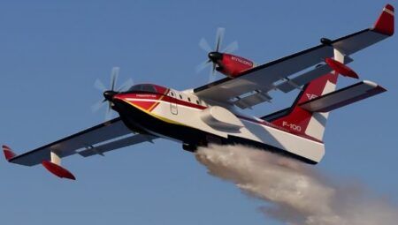 A rendering of the red-and-white Hynaero Fregate-F100 amphibious firefighting aircraft in flight, releasing a trail of water from beneath its fuselage