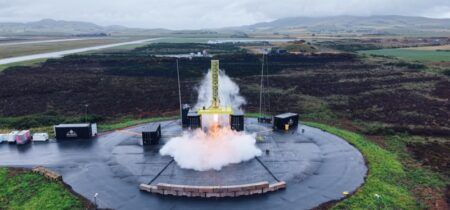 Skyrora advances XL rocket with hot-fire test A Skyrora test vehicle fires on a vertical static test stand on a circular pad, throwing up a plume of exhaust and steam, with the Scottish landscape behind